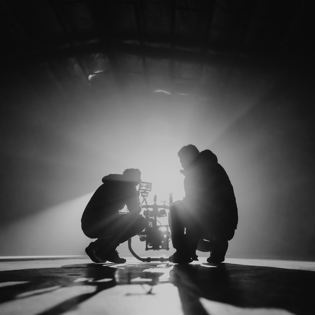 grayscale photography of two crouching men